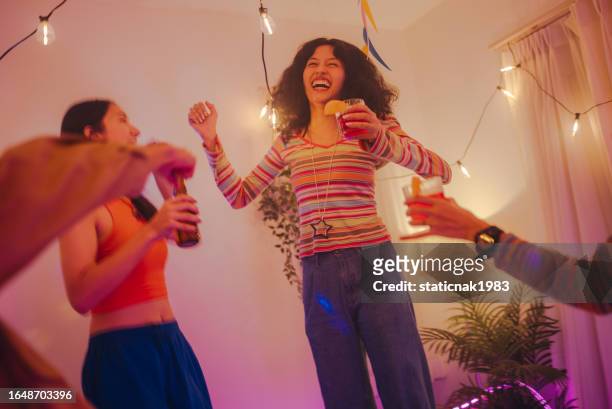 generation z students have fun with their multiracial friends singing, dancing, and drinking at a house party. - asian generation z stock pictures, royalty-free photos & images
