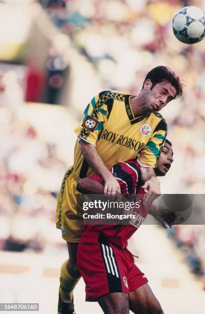 Bosnian footballer Sergej Barbarez of Rostock jumps above Brazilan footballer Emerson of Leverkusen during the German Bundesliga match between Bayer...