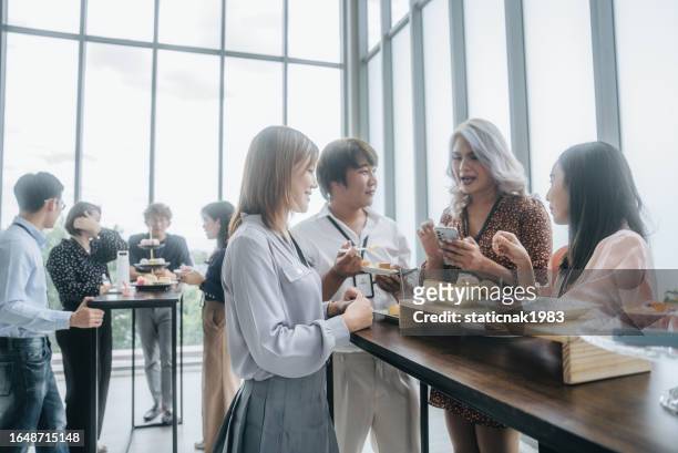 group of happy business people enjoying food and chatting during a break at a financial seminar in bangkok - dining presentation food imagens e fotografias de stock
