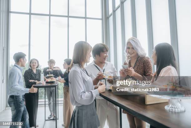 cheerful lgbtq group enjoying a meal and chat during breaks at a financial seminar. - party food and drink stock pictures, royalty-free photos & images
