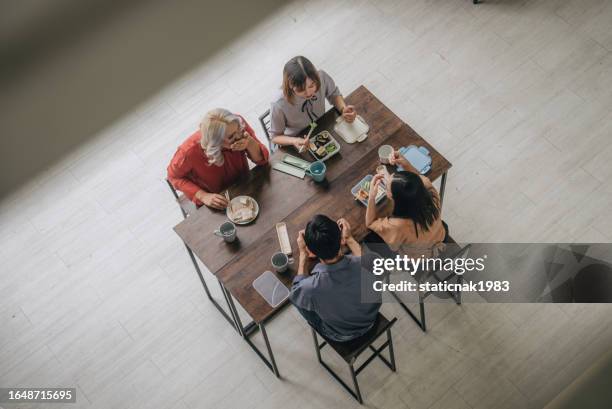 draufsicht auf die vielfalt gruppe asiatischer kollegen, die während der pausenzeit im büro ein glückliches mittagessen haben und sich unterhalten. - trans awareness dinner stock-fotos und bilder