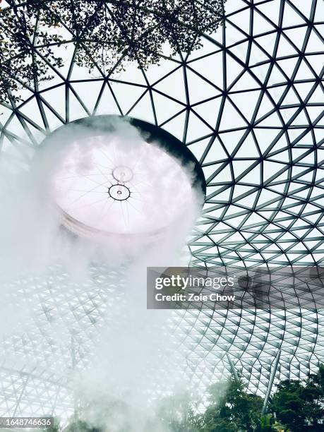 interior of the jewel changi airport with rain vortex, the world's tallest indoor waterfall - changi airport stock pictures, royalty-free photos & images