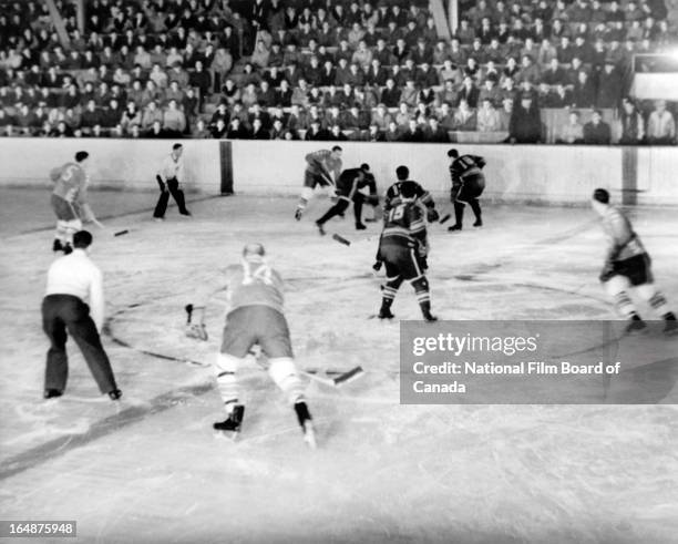 View of a hockey game between the Shawinigan Cataracts, in light uniforms, and the Montreal Royals held at the municipal arena of Shawinigan, Quebec,...