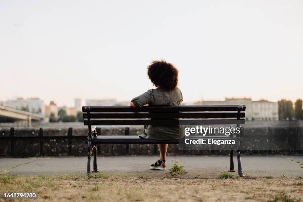 femme afro méconnaissable assise sur un banc de parc et se reposant - banc photos et images de collection