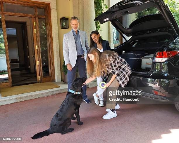 In this handout image provided by the Royal Household, King Felipe of Spain and Queen Letizia of Spain are seen helping Princess Sofia with her...