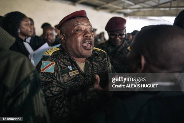 Colonel Mike Mikombe , one of the accused Republican Guard officers, argues with a lawyer after the hearing at the military court of Goma, eastern...