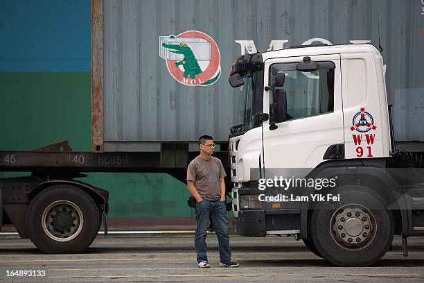 Container truck driver stands alongside a vehicle at the Kwai Chung Container Terminal on March 29, 2013 in Hong Kong, China. Over 100 workers, who...