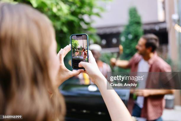 nahaufnahme einer frau, die ein foto von ihren lustigen freunden macht - fleischprodukt stock-fotos und bilder