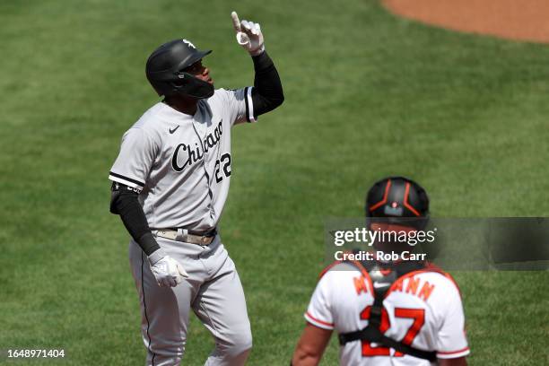 Oscar Colas of the Chicago White Sox celebrates in front of James McCann of the Baltimore Orioles after hitting a two RBI home run in the second...