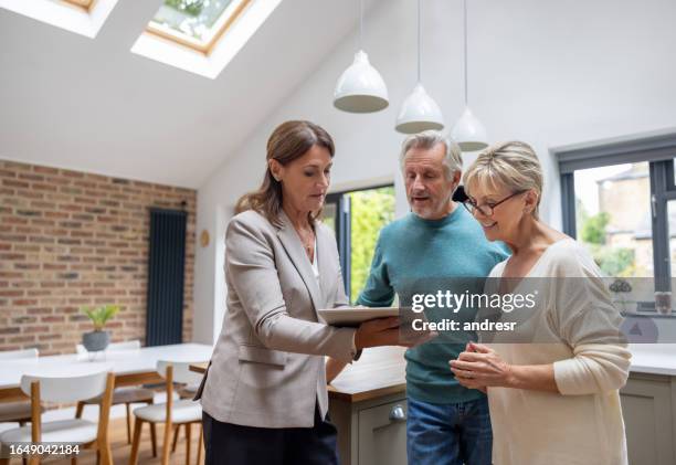real estate agent showing the blueprints of a house to a couple - landlord stock pictures, royalty-free photos & images