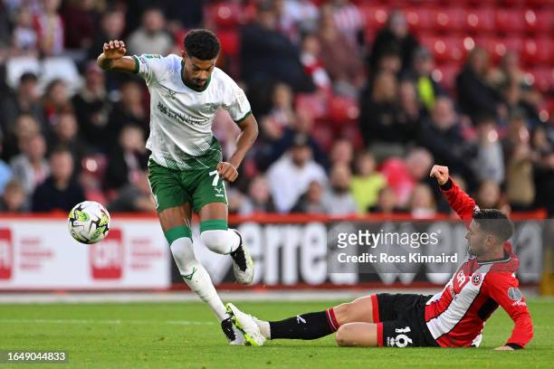 Reeco Hackett-Fairchild of Lincoln City is tackled by Oliver Norwood of Sheffield United during the Carabao Cup Second Round match between Sheffield...