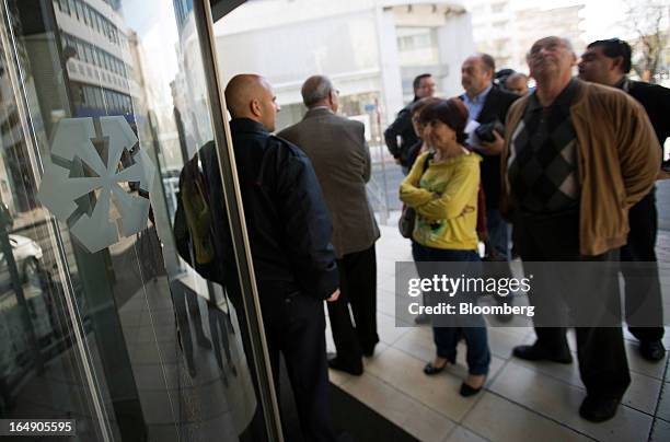 Customers queue outside a branch of a Cyprus Popular Bank Pcl, also known as Laiki Bank, in Nicosia, Cyprus, on Friday, March 29, 2013. Cypriots face...