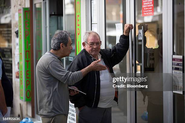 Customers wait their turn to be allowed access into a branch of a Cyprus Popular Bank Pcl, also known as Laiki Bank, in Nicosia, Cyprus, on Friday,...