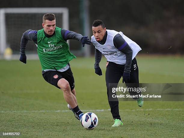 Lukas Podolski and Francis Coquelin of Arsenal during a training session at London Colney on March 29, 2013 in St Albans, England.