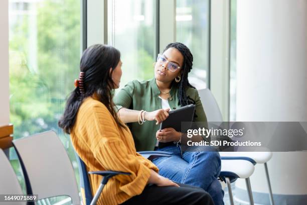 vulnerable woman shares something with therapist during therapy session - empathy stockfoto's en -beelden