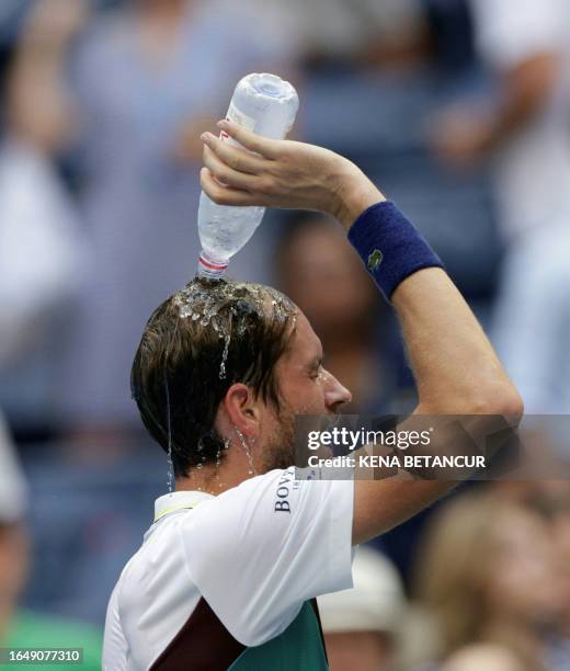 Russia's Daniil Medvedev pours water over his head after defeating Russia's Andrey Rublev during the US Open tennis tournament men's singles...