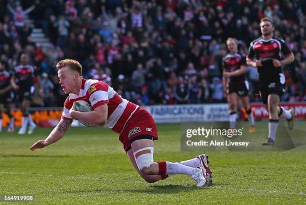 Dom Crosby of Wigan Warriors dives over the line to score his try during the Super League match between Wigan Warriors and St Helens at DW Stadium on...