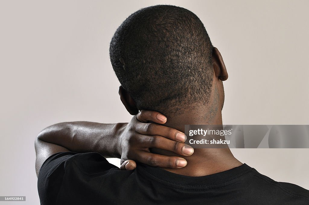 Male holding the back of his neck cause of pain