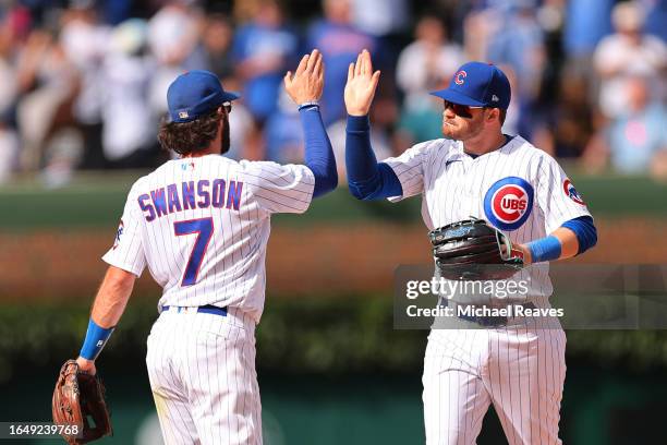 Dansby Swanson and Ian Happ of the Chicago Cubs celebrate after defeating the Milwaukee Brewers at Wrigley Field on August 30, 2023 in Chicago,...