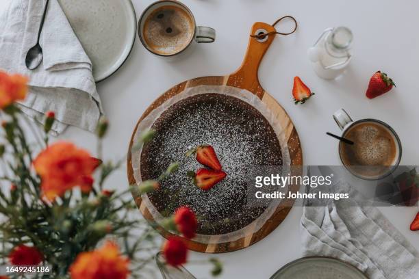 freshly baked chocolate cake with strawberries on table - coffee cake stockfoto's en -beelden