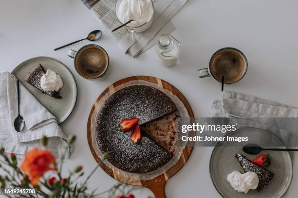 freshly baked chocolate cake with strawberries on cream on table - chocolate cake above stock pictures, royalty-free photos & images