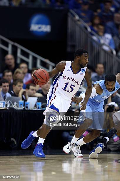 Elijah Johnson of the Kansas Jayhawks drives to the goal against Dexter Strickland of the North Carolina Tar Heels during the third round of the 2013...