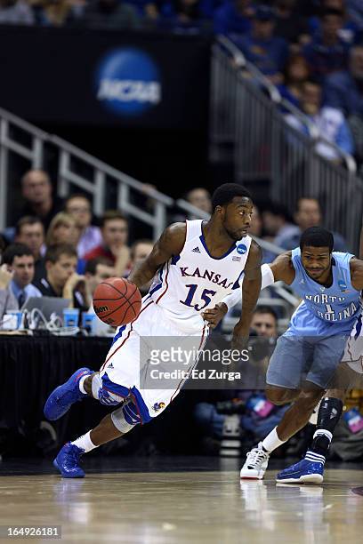 Elijah Johnson of the Kansas Jayhawks drives to the goal against Dexter Strickland of the North Carolina Tar Heels during the third round of the 2013...