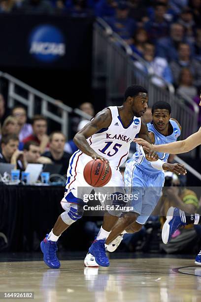 Elijah Johnson of the Kansas Jayhawks drives to the goal against Dexter Strickland of the North Carolina Tar Heels during the third round of the 2013...