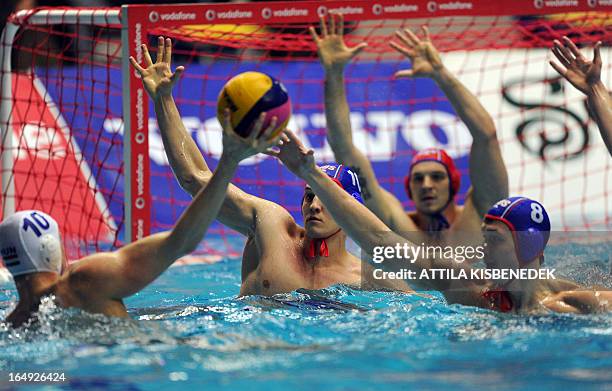 Russia's players, Sergey Lisunov , goalkeeper Victor Ivanov and Ivan Nagaev save the goal against Hungary's Denes Varga during the Waterpolo World...