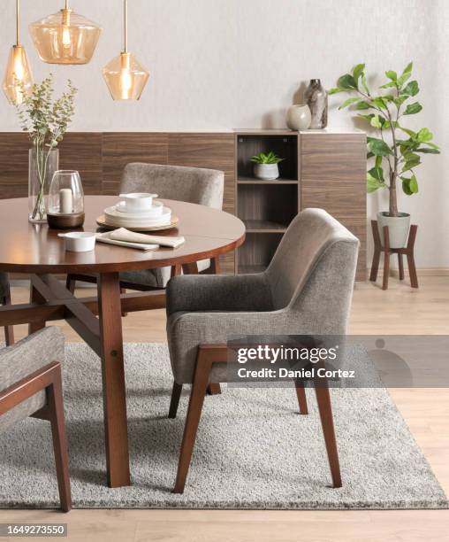 a modern wooden dining set in a stylishly designed room featuring hardwood floors and contemporary furniture - rustic dining room stock pictures, royalty-free photos & images