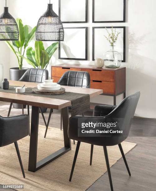 a modern dining room with a wooden table accompanying chairs set, blank picture frames mockup hanging on wall - accompanying stock pictures, royalty-free photos & images