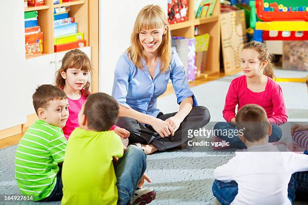 insegnante parla con i bambini. - bambini seduti in cerchio foto e immagini stock