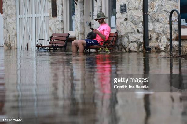 Eliah Corcoran sits on a bench in flood waters after Hurricane Idalia passed offshore on August 30, 2023 in Crystal River, Florida. Hurricane Idalia...
