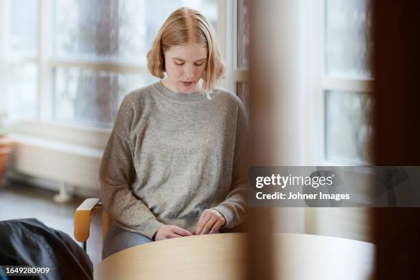 teenage girl in waiting room looking away - hospital waiting room stockfoto's en -beelden