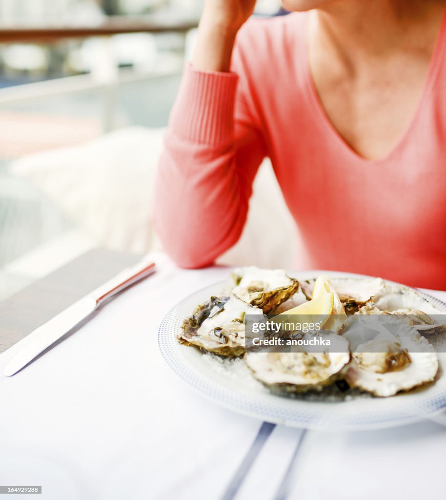 Woman in restaurant with plate of oysters