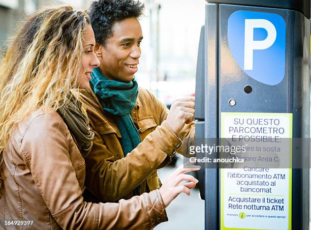 lovely couple using parking ticket machine in the city - happiness meter stock pictures, royalty-free photos & images