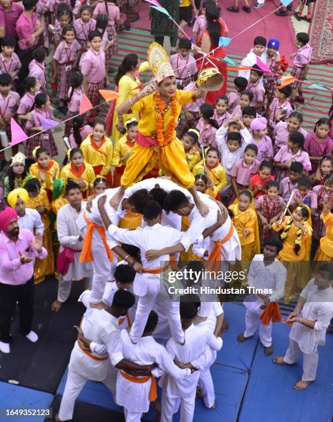School children dressed up as Lord Krishna break the Dahi Handi during celebrations on the eve of Janmashtami, at Sun Valley Public School on...