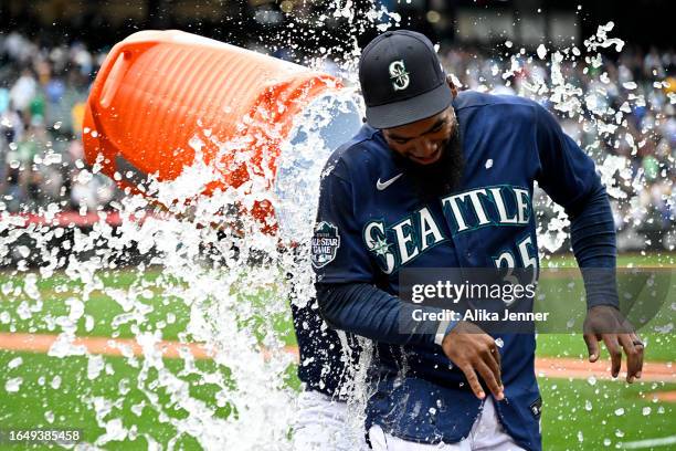 Teoscar Hernandez of the Seattle Mariners gets a sports drink shower by Ty France after the game against the Oakland Athletics at T-Mobile Park on...