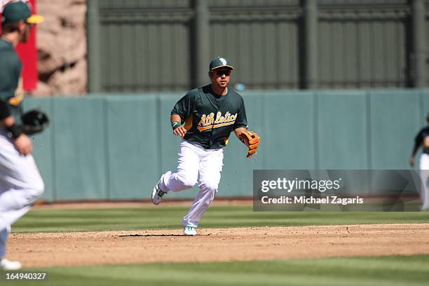 Hiroyuki Nakajima of the Oakland Athletics fields during a spring training game against the Colorado Rockies at Phoenix Municipal Stadium on March 2,...