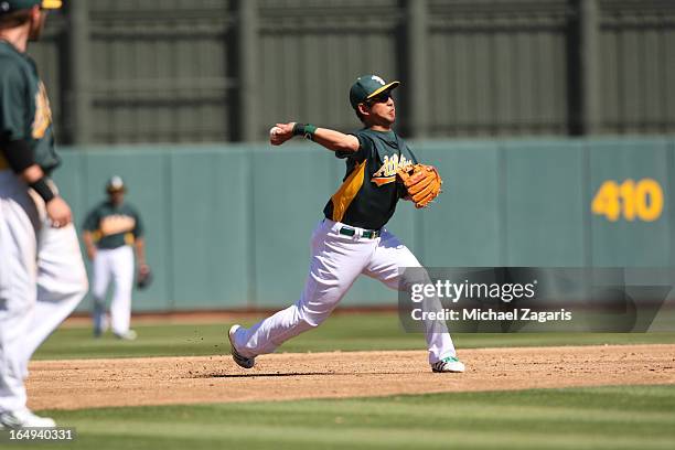 Hiroyuki Nakajima of the Oakland Athletics fields during a spring training game against the Colorado Rockies at Phoenix Municipal Stadium on March 2,...