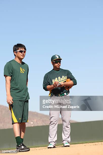 Hiroyuki Nakajima of the Oakland Athletics stands with interpreter Hiroo Nishi during a spring training workout at Papago Park on February 17, 2013...