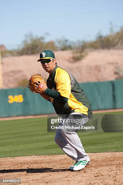 Hiroyuki Nakajima of the Oakland Athletics does infield drills during a spring training workout at Phoenix Municipal Stadium on February 23, 2013 in...