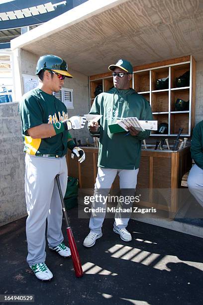 Hitting Coach Chili Davis of the Oakland Athletics talks with Hiroyuki Nakajima in the dugout prior to the spring training game against the Milwaukee...