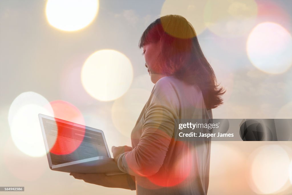 Woman using laptop and lights