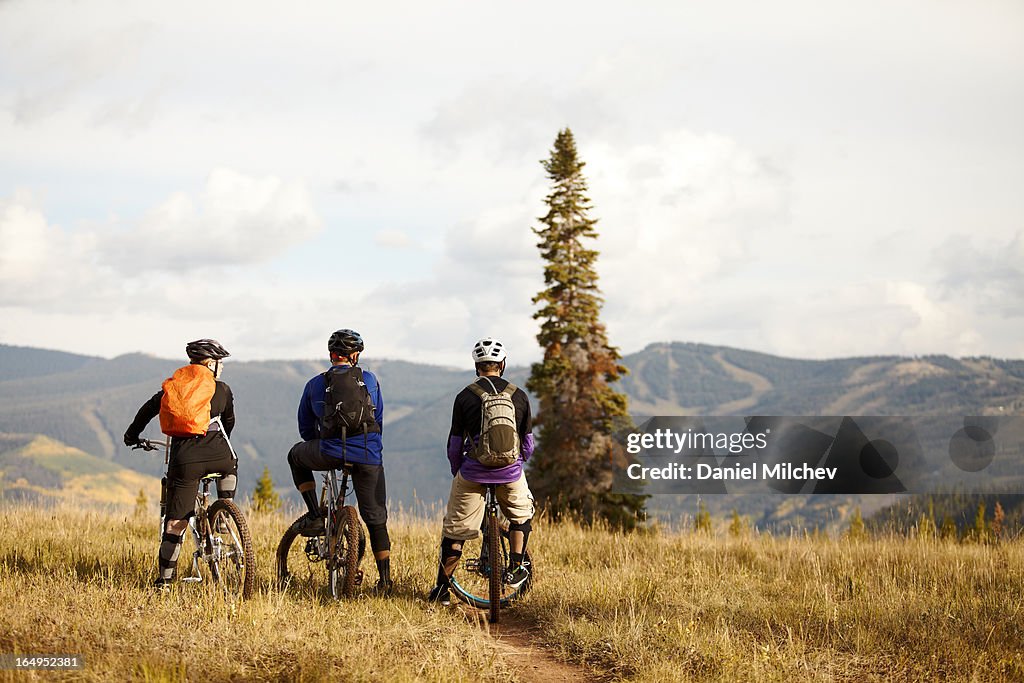 Friends looking at the mountains, sitting on bikes