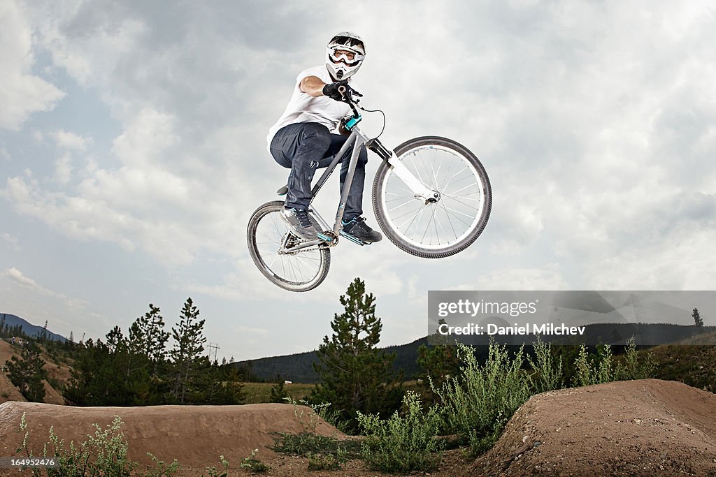 Guy jumping at a bike park.