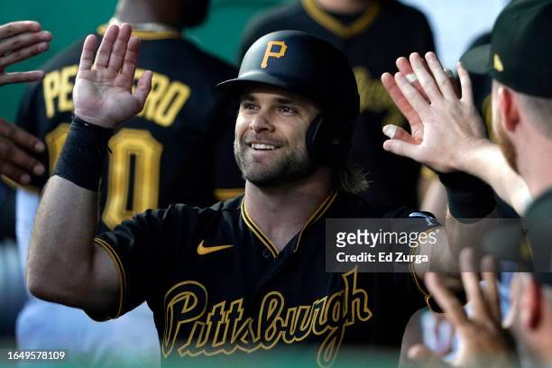Vinny Capra of the Pittsburgh Pirates is congratulated by teammates after scoring on a Jack Suwinski single in the second inning against the Kansas...