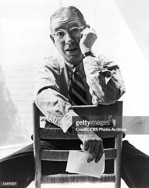 Portrait of American poet Ogden Nash sitting backwards on a chair, August 1953 .