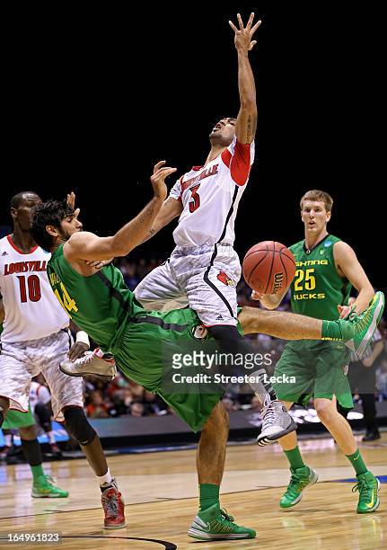 Peyton Siva of the Louisville Cardinals loses the ball as he drives in the second half against Arsalan Kazemi of the Oregon Ducks during the Midwest...
