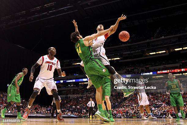 Peyton Siva of the Louisville Cardinals loses the ball as he drives in the second half against Arsalan Kazemi of the Oregon Ducks during the Midwest...